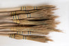 Set of brooms with straw bristles on a white background