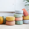 A collection of round floor dots in various colors, arranged in a stacked formation, some with a leather tag.