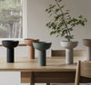 Set of modern planters on a wooden table with a neutral background