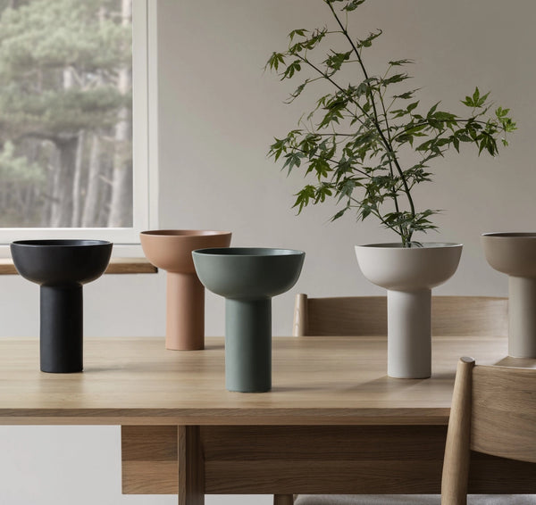 Set of modern planters on a wooden table with a neutral background