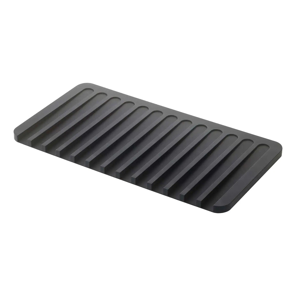 A dark gray rectangular mat with parallel raised ridges, shown at an angle on a plain white background.
