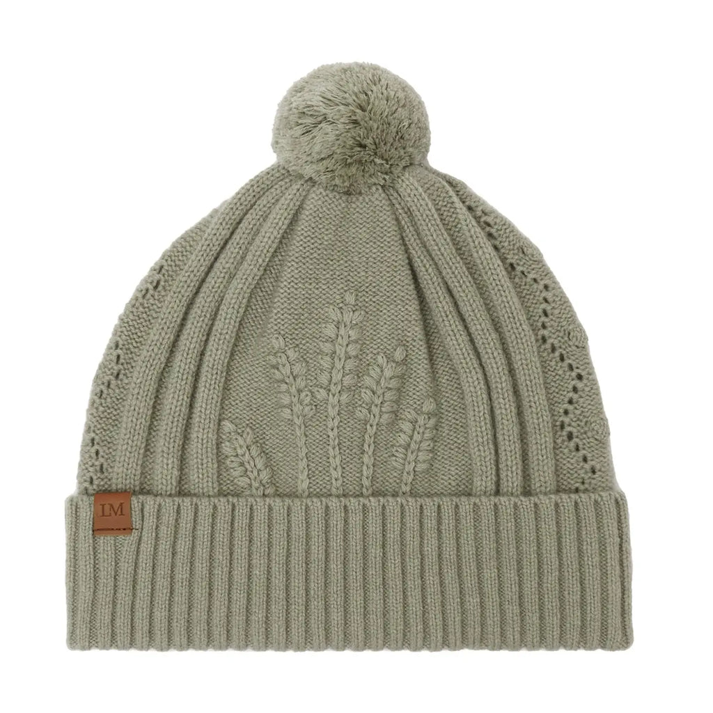 Sage green knit beanie with a pom-pom on a white background