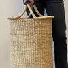 Person holding a woven basket with a plain background