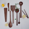 Set of wooden kitchen utensils on a light background with lemons and herbs.