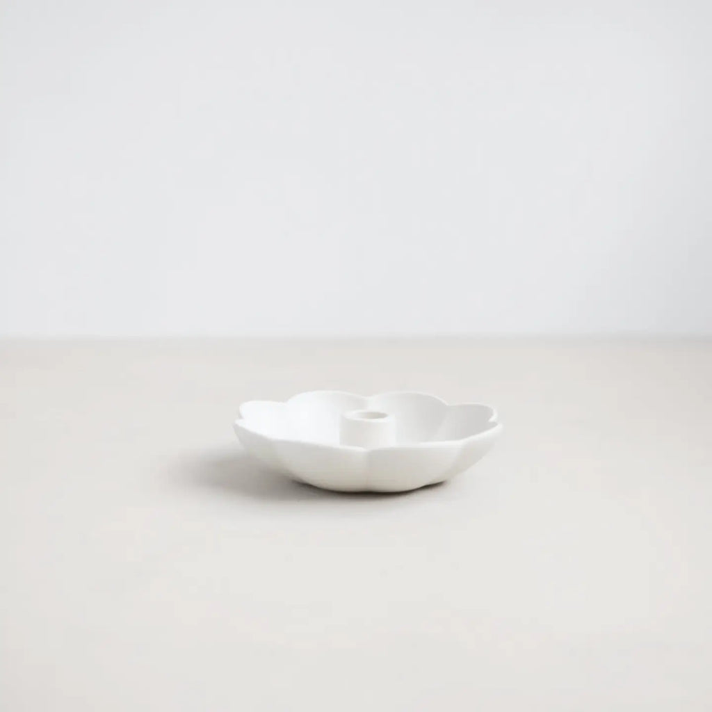 White ceramic candle holder on a light gray background
