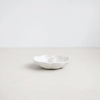 White ceramic candle holder on a light gray background