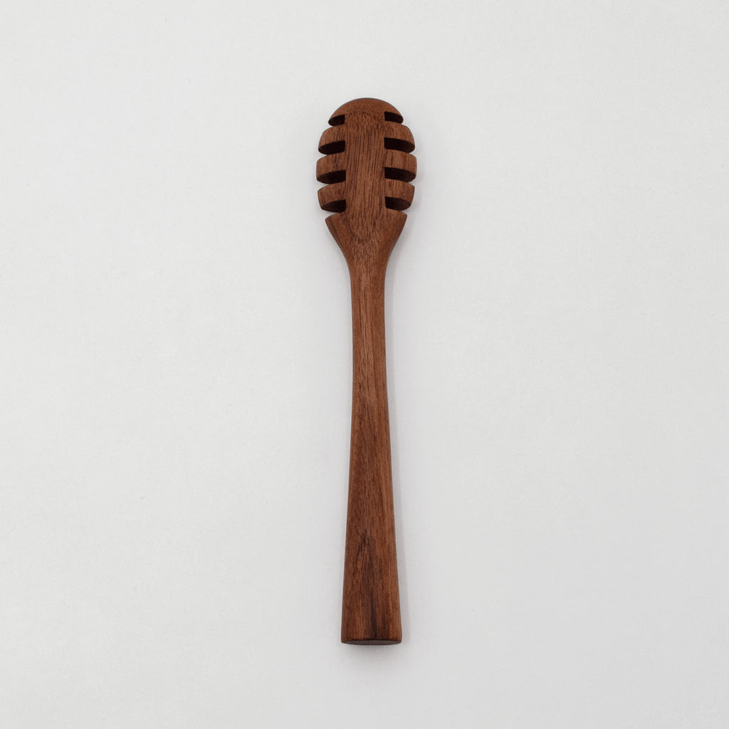 A 6-inch walnut wood honey dipper with a smooth finish and a rounded scooping end.