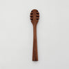 A 6-inch walnut wood honey dipper with a smooth finish and a rounded scooping end.