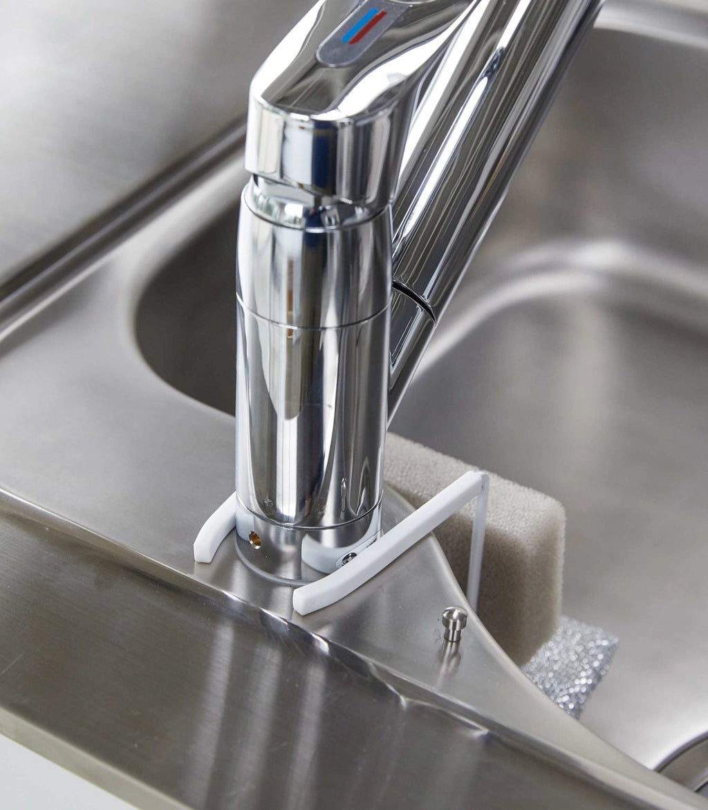 Chrome kitchen faucet on a stainless steel sink
