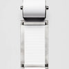 Metallic task roll holder with a roll of white lined paper on a white background