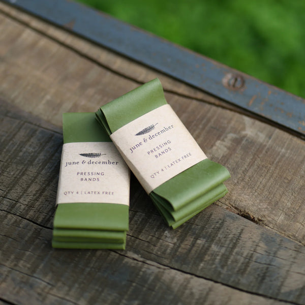 Green pressing bands with labels on a wooden surface