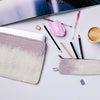 Desk with stationery items including pens, pencils, and a cup of coffee on a white surface.