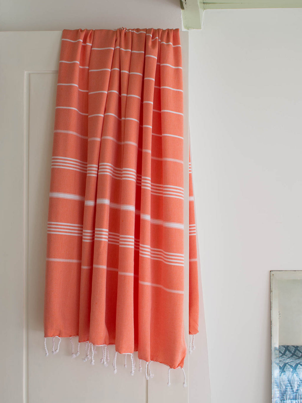 Coral checkered towel hanging on a white door
