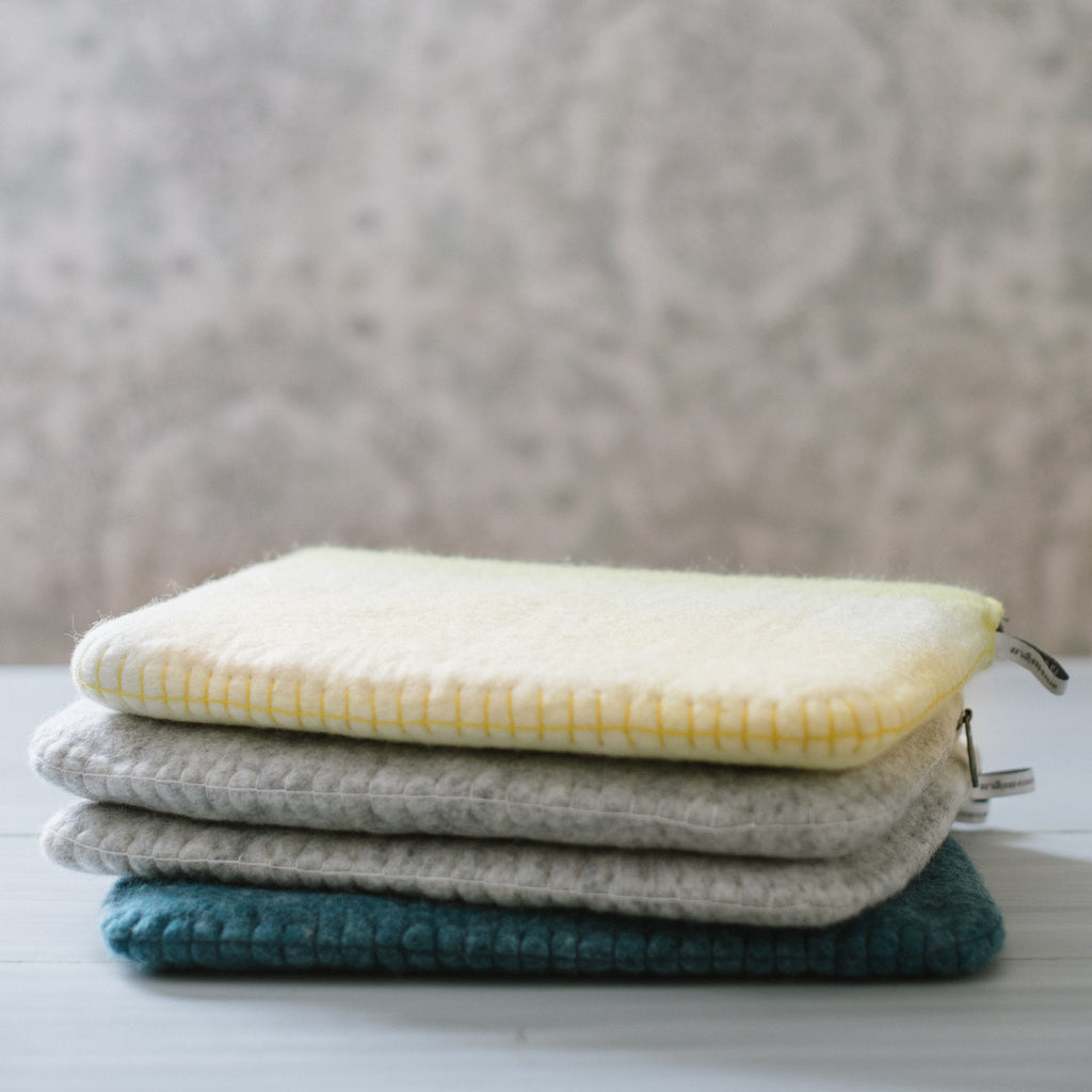 Laptop cases in gray, blue, and yellow.