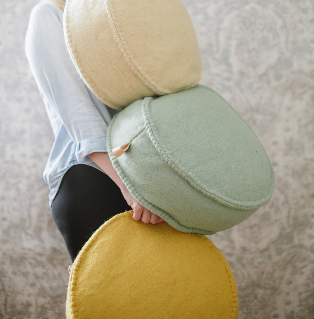 A person holding a collection of round floor dots in various colors.