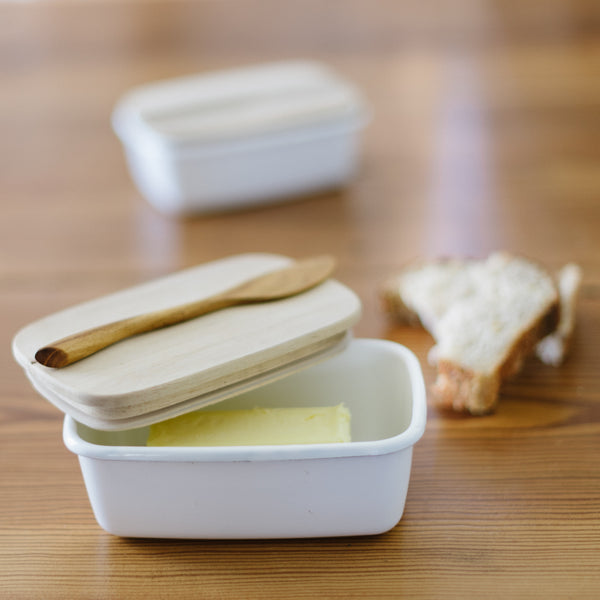 Enamel Storage Container with Acacia Wood Lid with a stick of butter inside of it.