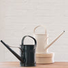 Two metal watering cans with enamel exterior