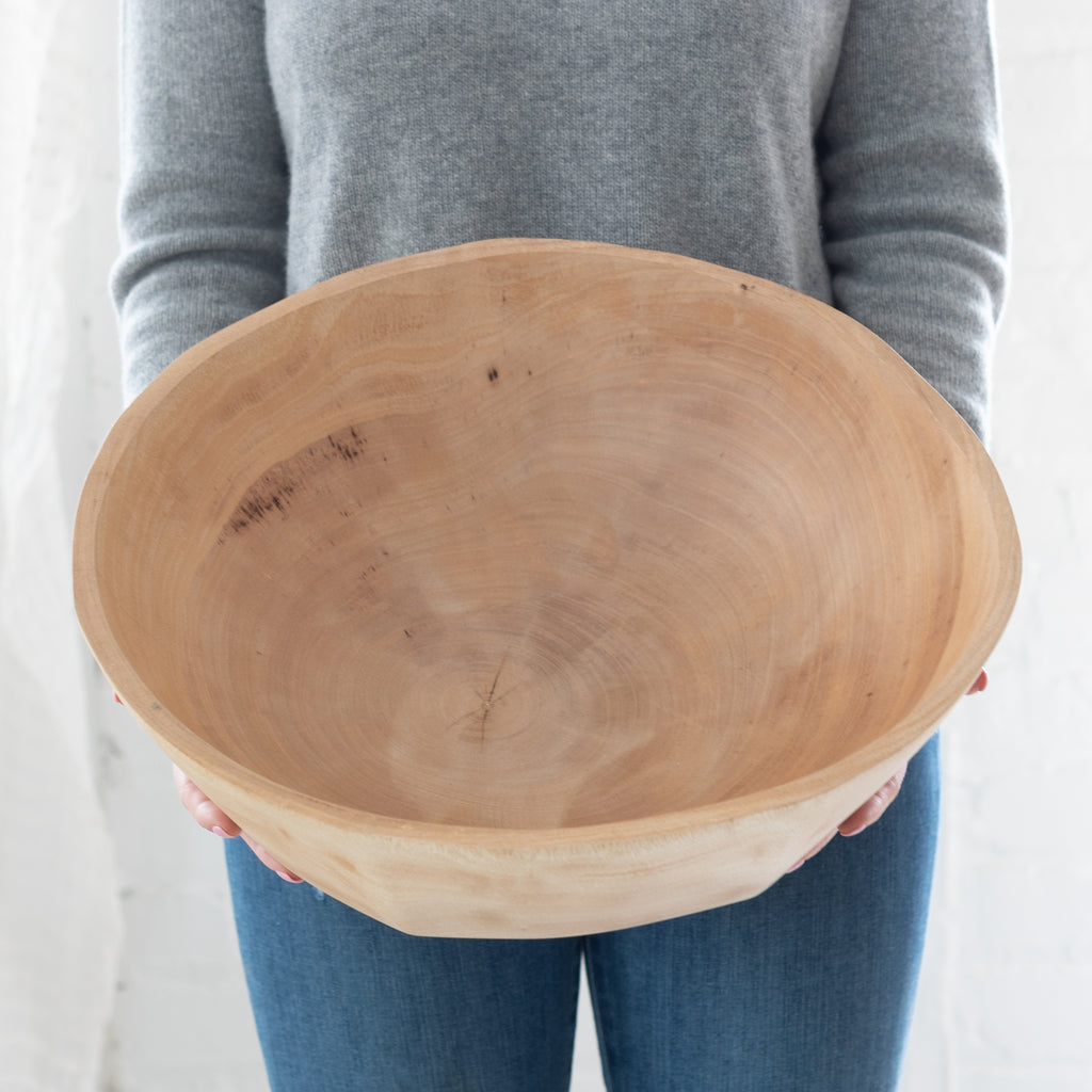 woman holding a large mango wood bowl