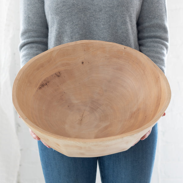 woman holding a large mango wood bowl