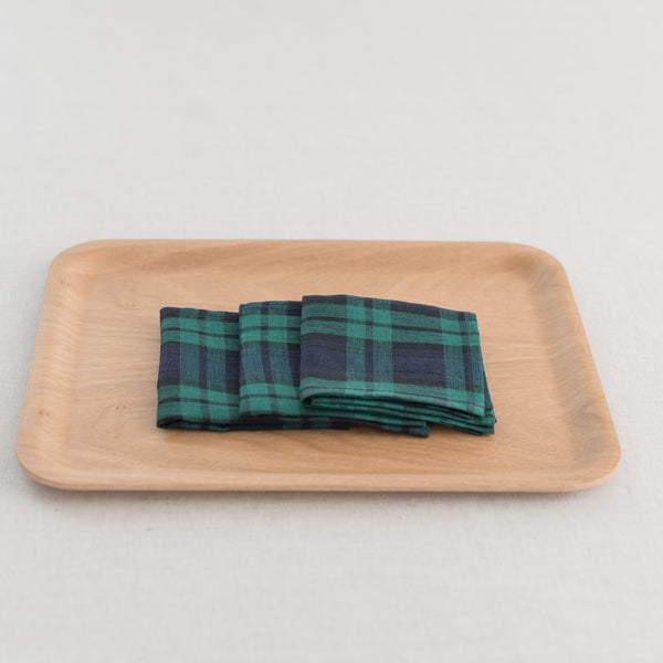 A folded checkered handkerchief on a wooden tray