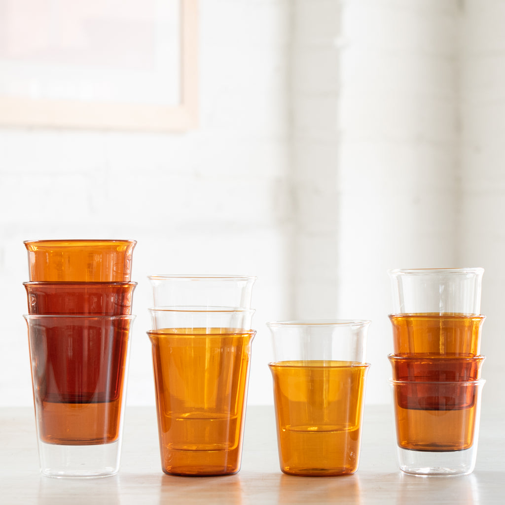 A variety of elegant glasses, some amber and some clear glass.