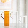 Three different glassware pitchers. One is amber, and two are clear.